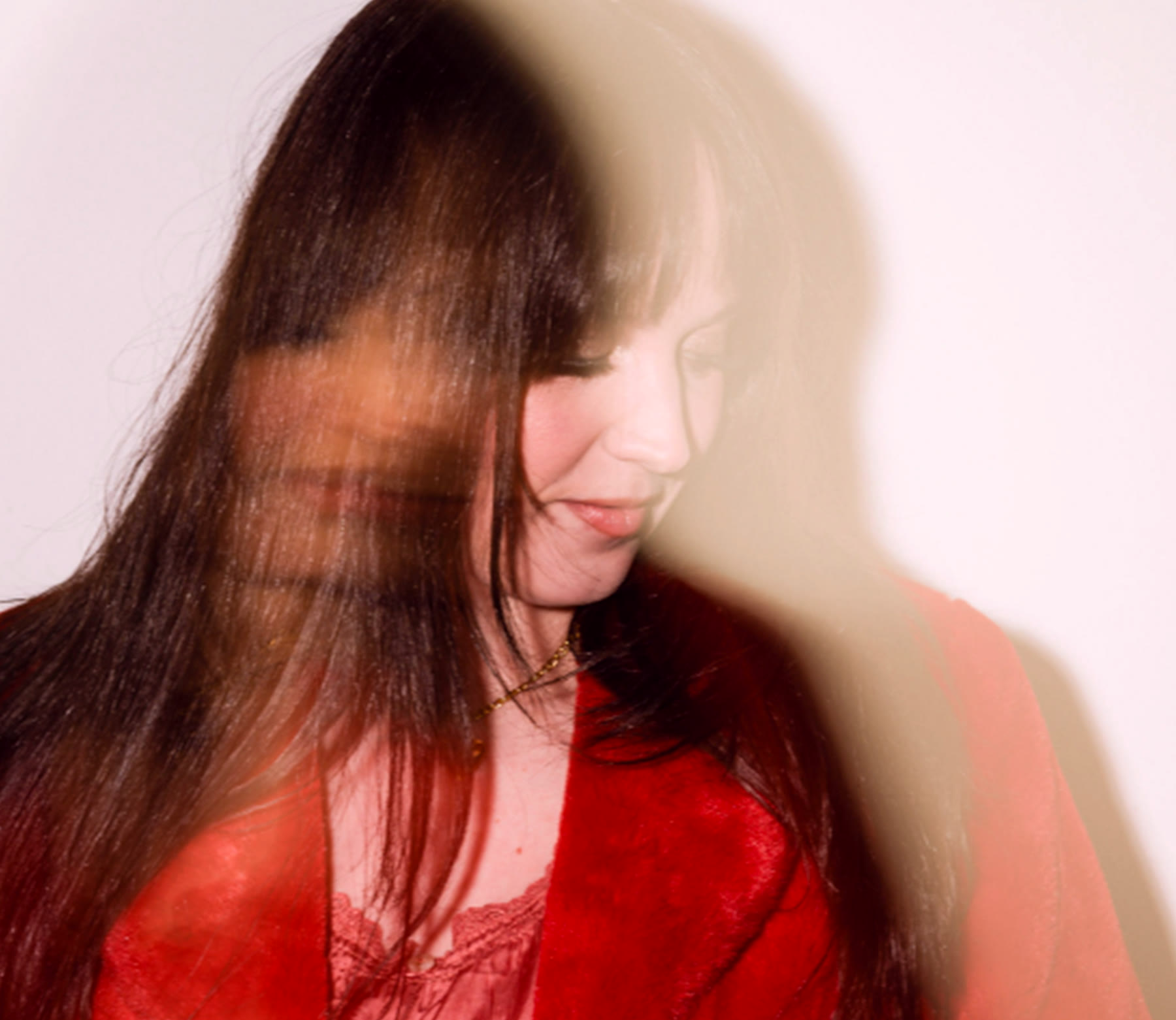 Margo Pearson turning her head, caught in a long exposure so her face and hair smear into a second image of themselves.