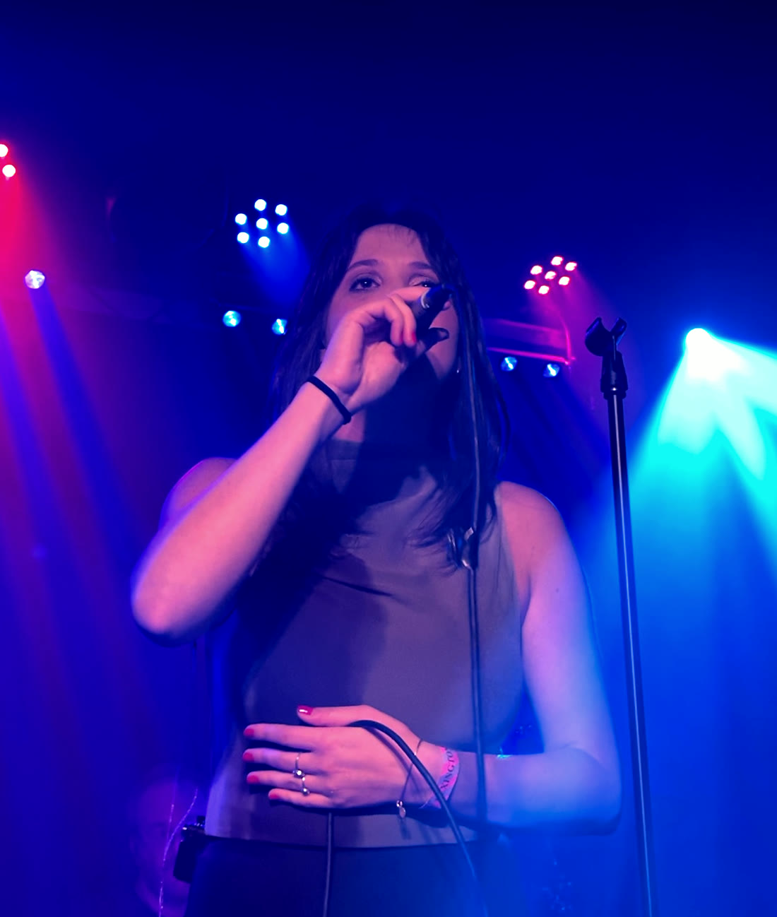 Margo Pearson singing under blue and magenta stage light at The Lexington, London.