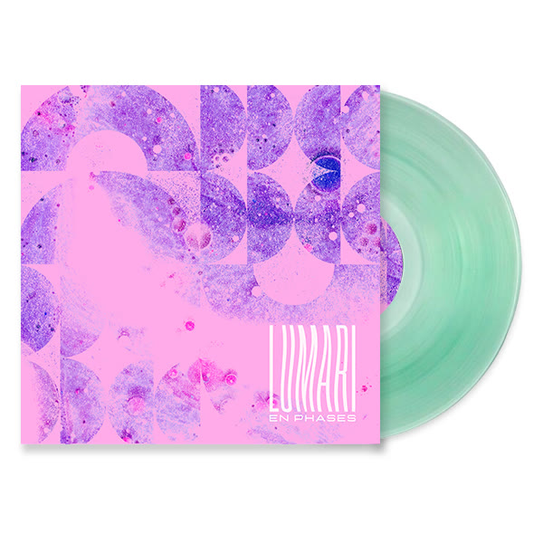 The En Phases LP: pink sleeve with violet halftone arcs, coke-bottle green vinyl pulled out beside it.